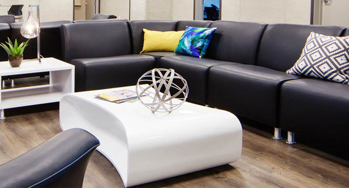 Seating area with modern black sofas and white tables