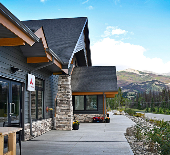 Building exterior with stone accents and mountains in the background