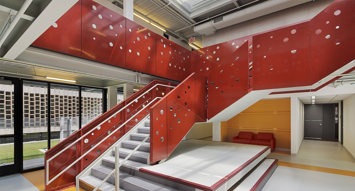 Interior staircase with red perforated metal panels