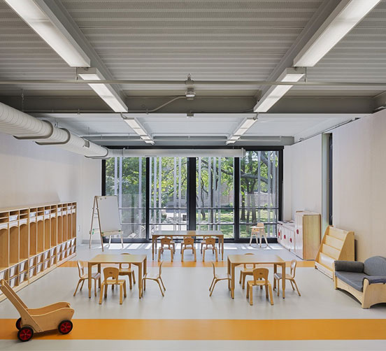 Open classroom with several wood tables and chairs