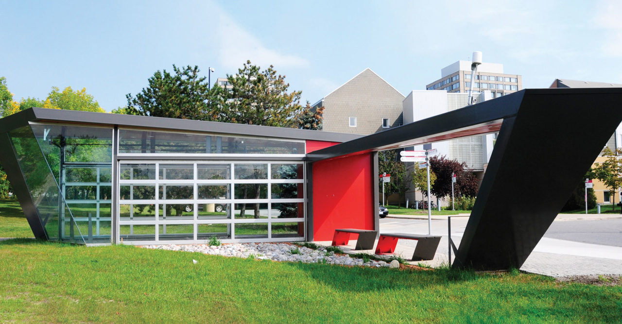 Modern bus shelter with large glass panels and red accent wallt