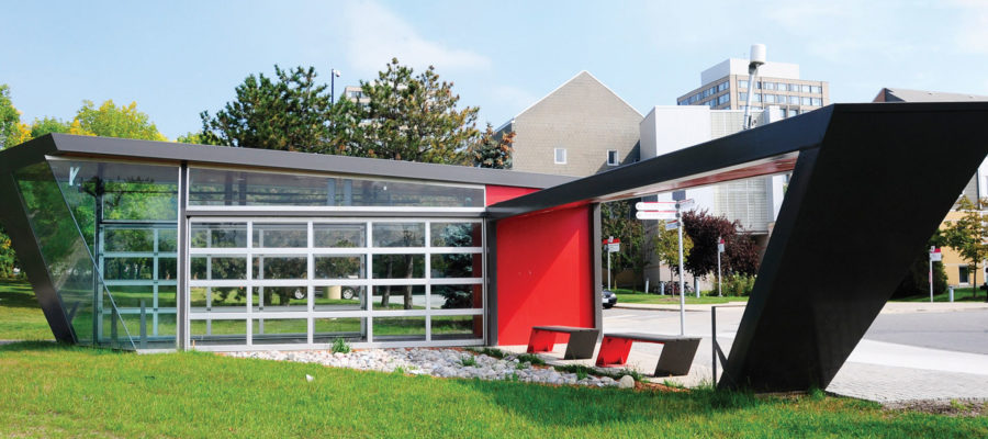 Modern bus shelter with large glass panels and red accent wallt